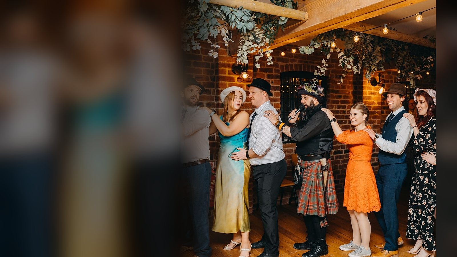 A packed barn dancefloor mid-ceilidh, guests of all ages hand in hand