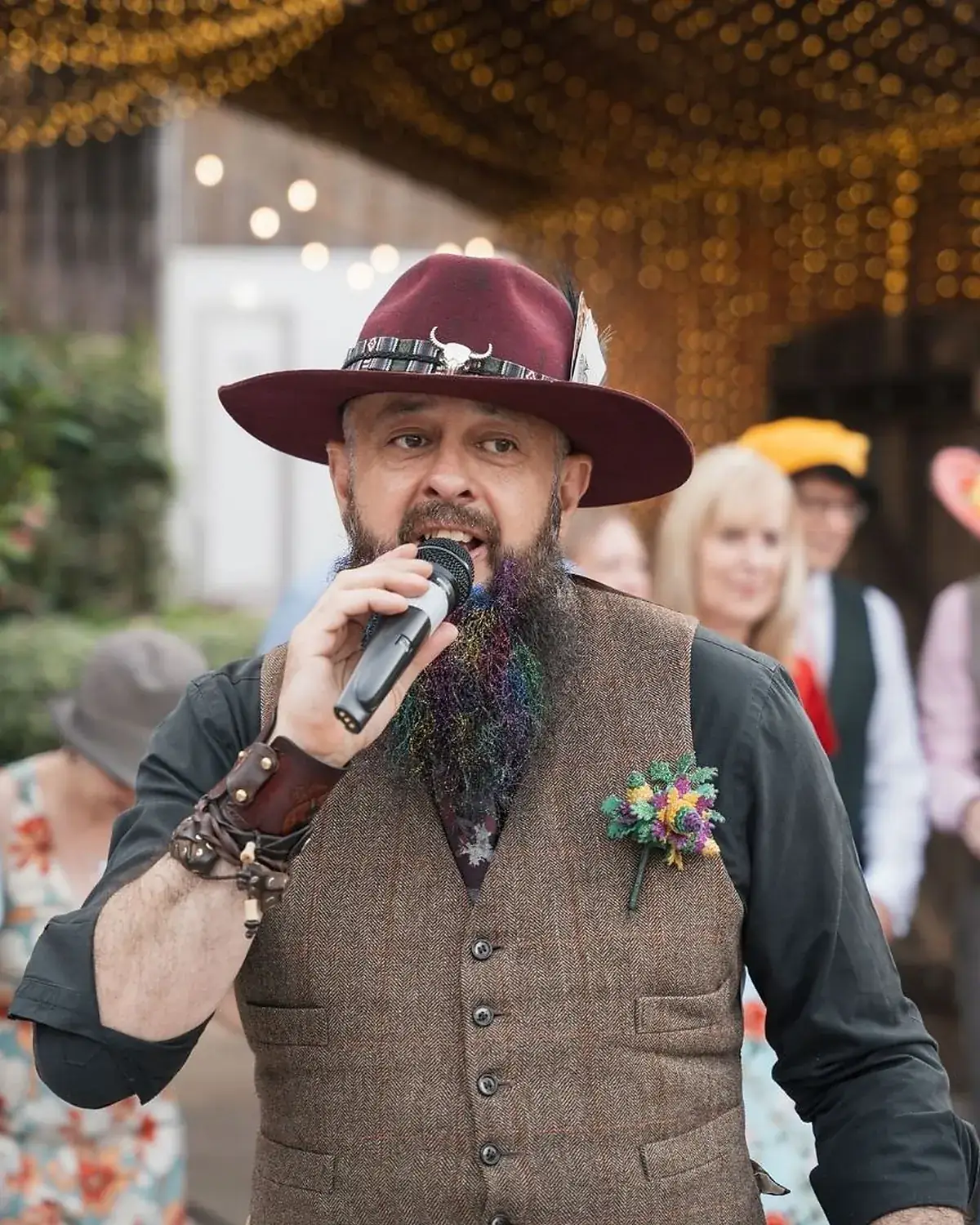 Schuggie calling into the microphone, guests dancing behind him